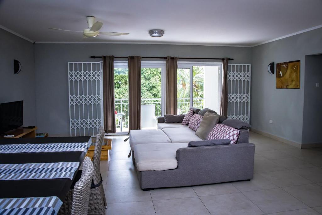 a living room with a couch and a tv at Riverside Residence - BEAU VALLON in Beau Vallon