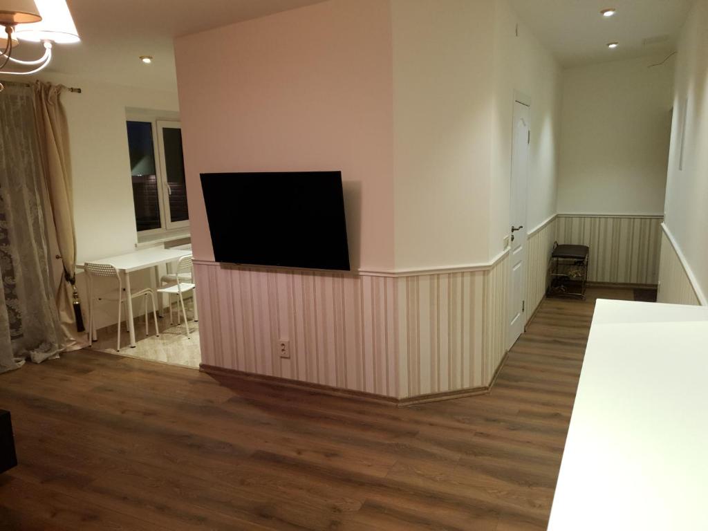 a living room with a flat screen tv on a wall at Ditemo center apartment self check in in Šiauliai