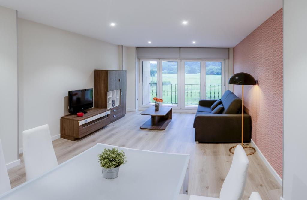 a living room with a couch and a tv at Apartamentos La Albarca in Hoznayo