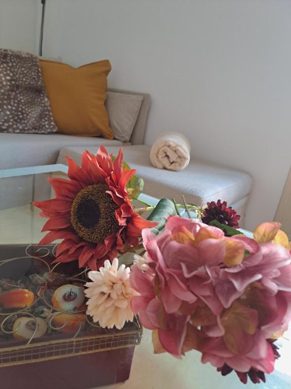 - une table avec des fleurs et un canapé dans l'établissement Apartamento nuevo en el centro de Madrid, à Madrid