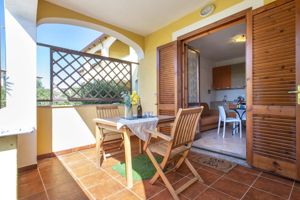 cocina y comedor con mesa y sillas en Baia delle mimose 2, en Badesi