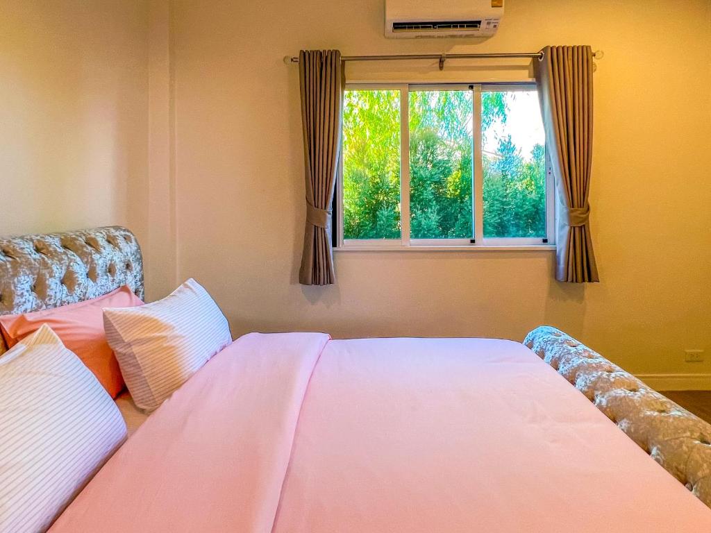 a bedroom with a bed and a window at Himehome at Suanbanpaeng 