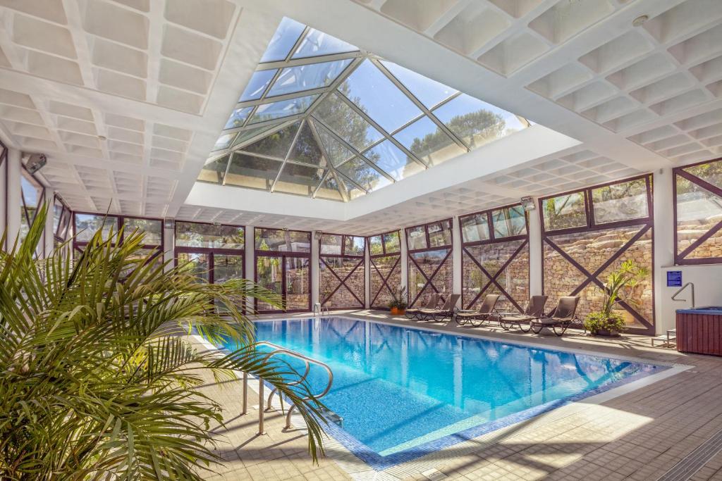 an indoor pool in a building with a large skylight at Vilar do Golf in Quinta do Lago