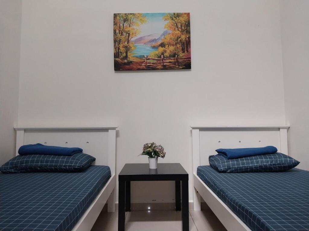 2 camas en una habitación con una foto en la pared en 4 airconditioned rooms and fully furnished Guesthouse in Muar Town en Muar