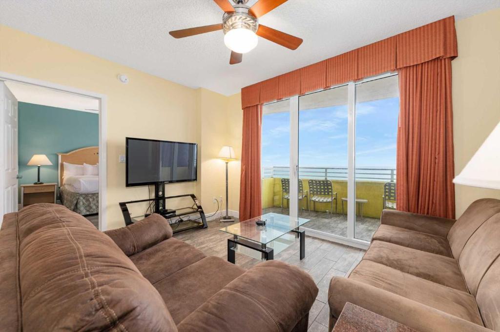 a living room with a couch and a flat screen tv at Luxury 3BR Villa Wyndham Ocean Walk Resort in Daytona Beach