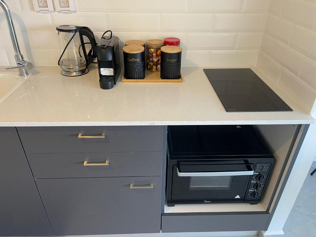 a kitchen counter with a counter top with a microwave at oR-Ya Suite in Eilat