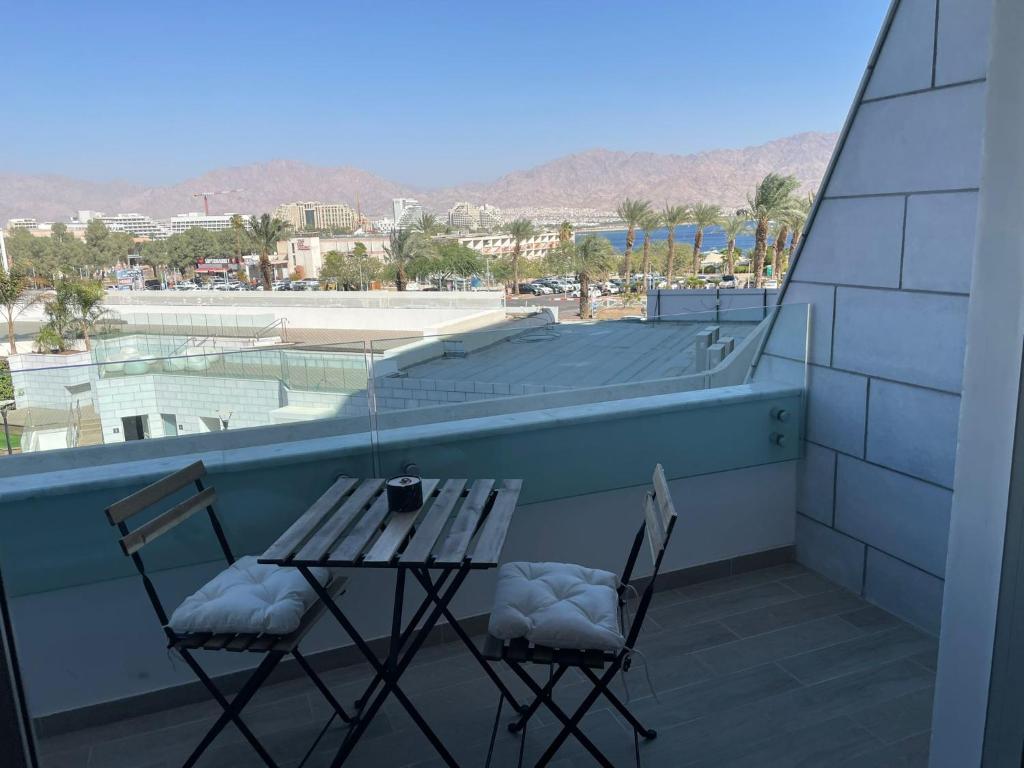 zwei Stühle und ein Tisch auf einem Balkon mit Aussicht in der Unterkunft oR-Ya Suite in Eilat