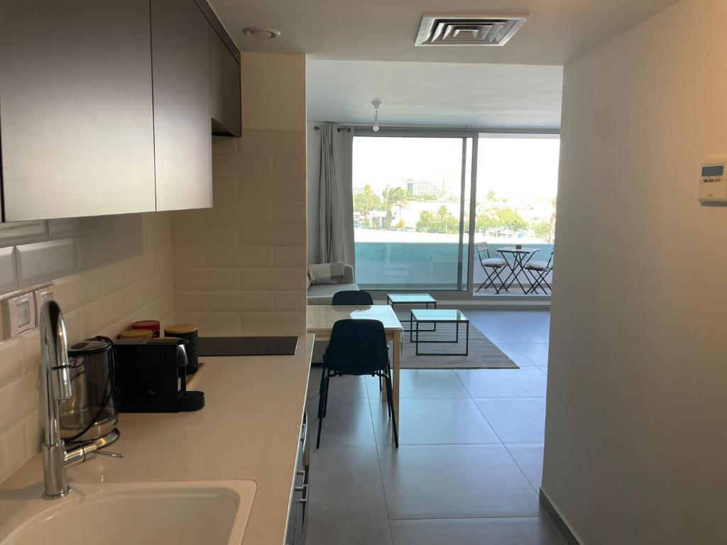 a kitchen with a sink and a table with chairs at oR-Ya Suite in Eilat