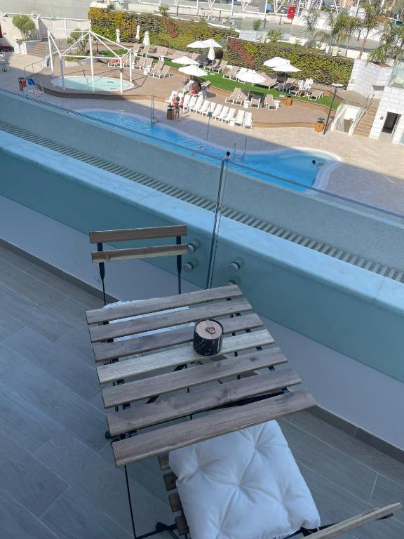 a wooden bench sitting next to a swimming pool at oR-Ya Suite in Eilat