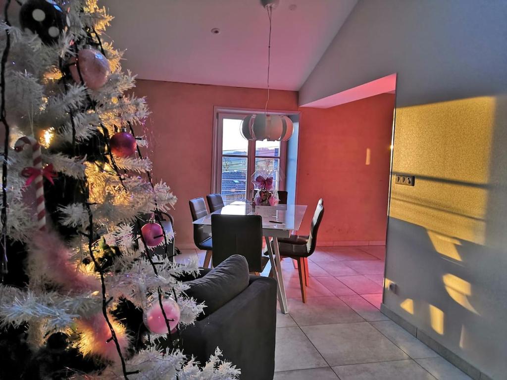 ein Wohnzimmer mit einem Weihnachtsbaum und einem Tisch in der Unterkunft Le patio d'antan, le cosy in Florémont