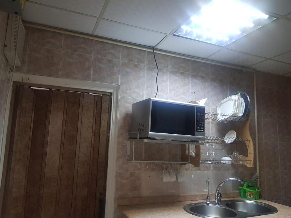baño con lavabo y TV en la pared en Fabulous Apartment in Sheraton Heliopolis ,5 minutes from Cairo Airport en El Cairo