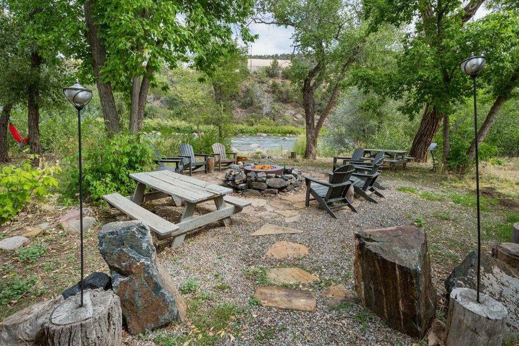 a picnic table and benches in a park with trees at CR 213 - 3 Bedroom in Durango