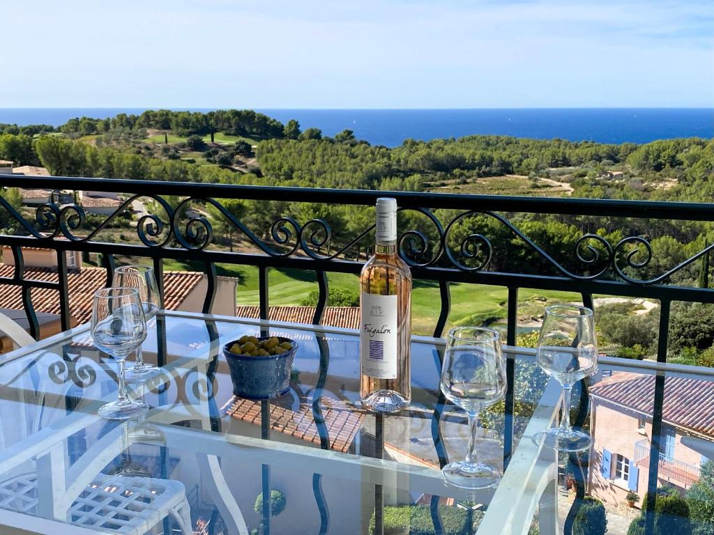 a bottle of wine sitting on a table with wine glasses at T3 vue mer exceptionnelle au domaine Frégate Bandol in Saint-Cyr-sur-Mer