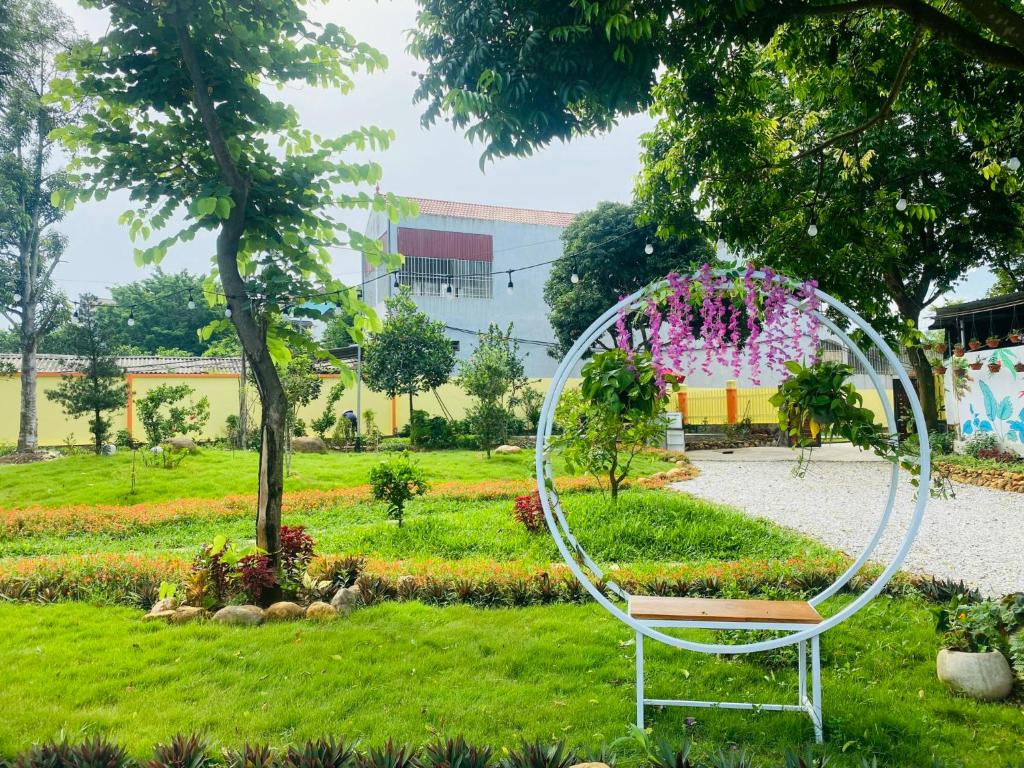 a white circle sculpture in a park with a bench at Homestay Bài Văn garden in Ba Vì