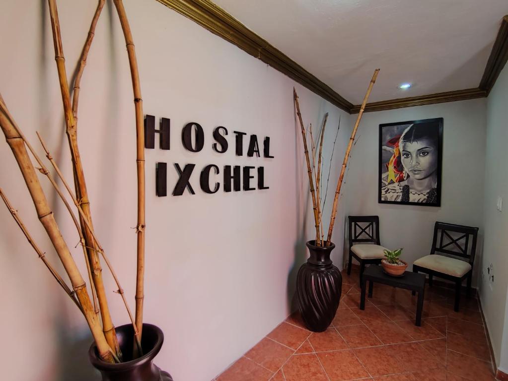 un pasillo con jarrones y un cartel en la pared en Hostal Ixchel - WiFi, Hot Water, AC, in Valladolid Downtown en Valladolid