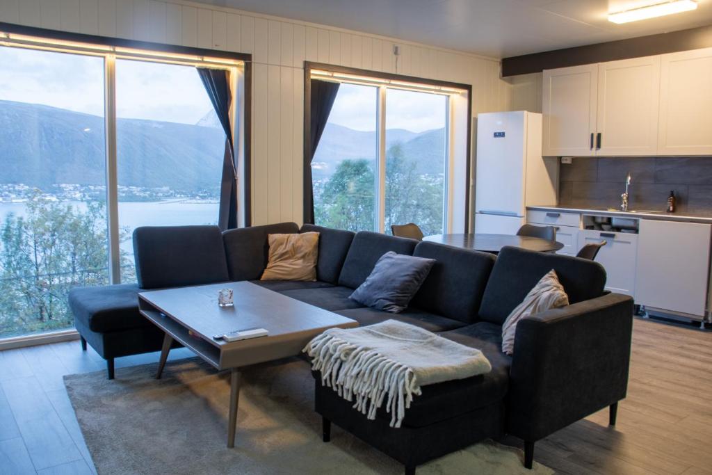 a living room with a couch and a table at Modern Fjord View Apartment in Tromsø