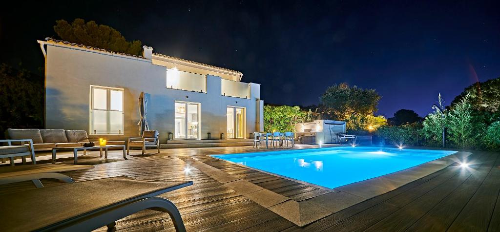 a swimming pool in front of a house at night at Villa bleu Tropez in Gassin