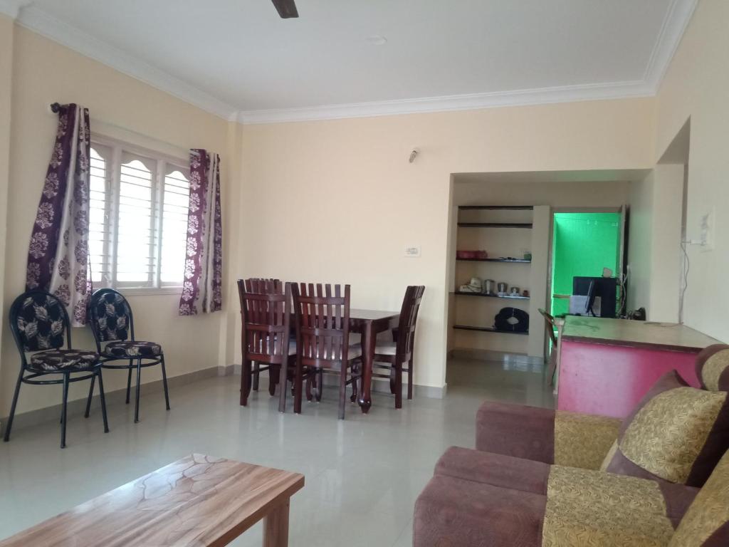 a living room with a couch and a table and chairs at Bangalore homestay in Bangalore