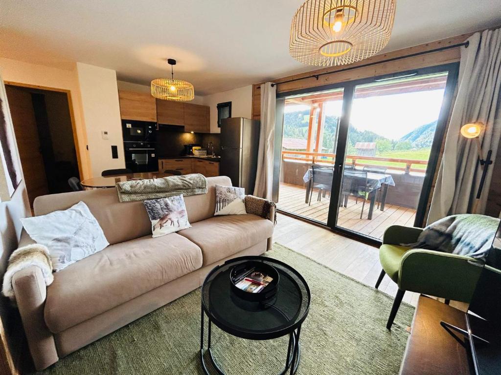 un salon avec un canapé et une table dans l'établissement Les Gets - Appartement dans une résidence neuve - FR-1-623-4, aux Gets