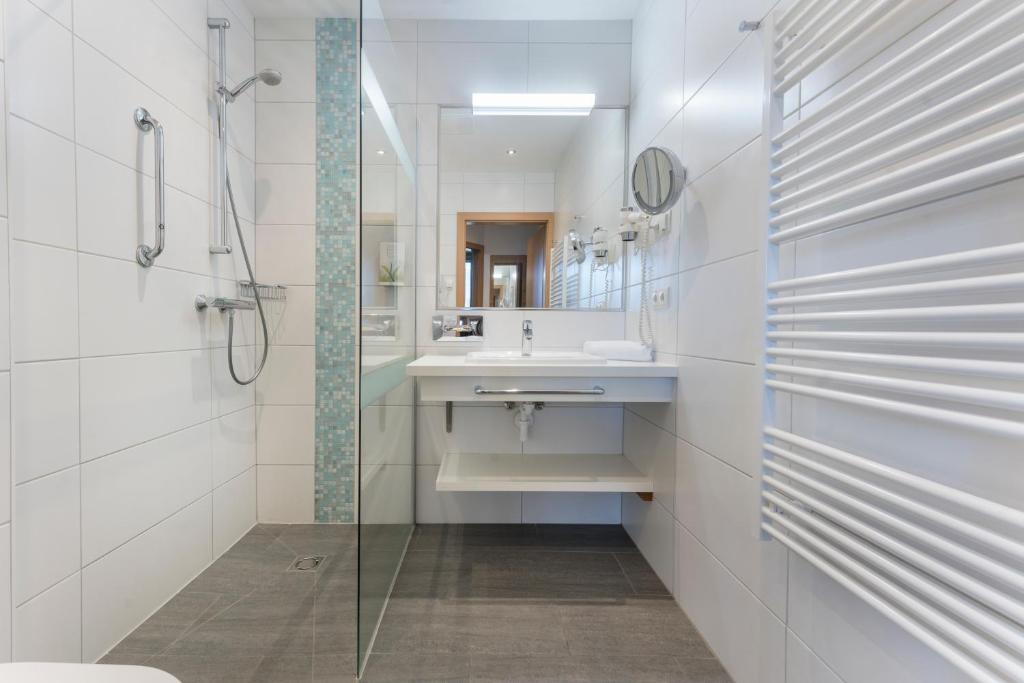 bagno bianco con lavandino e doccia di Alpine Club Resort a Schladming