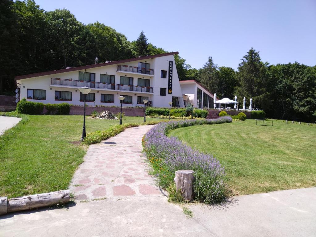 un grand bâtiment avec une cour herbeuse devant lui dans l'établissement Hotel Kovanlika 2, à Razgrad