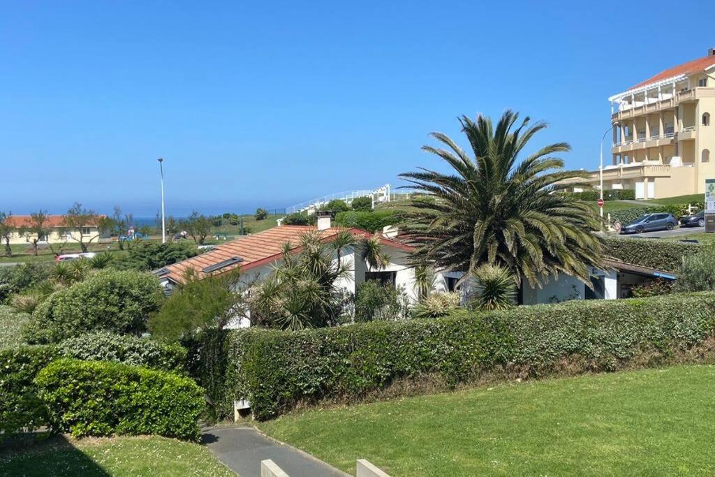 ein Haus mit einer Palme neben einem Gebäude in der Unterkunft Appartement vue mer à 100m des plages, classé 4* in Biarritz