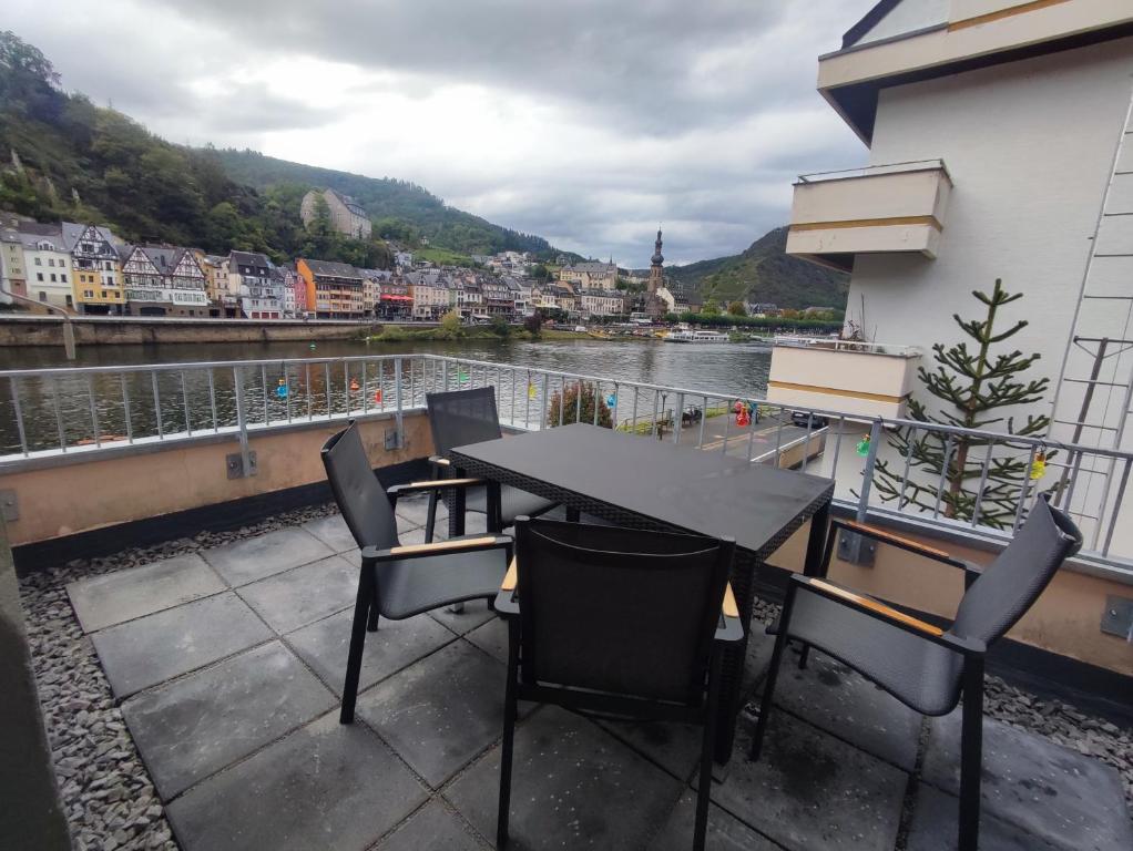 a table and chairs on a balcony overlooking a river at Gästehaus im Alten Fährhaus in Cochem