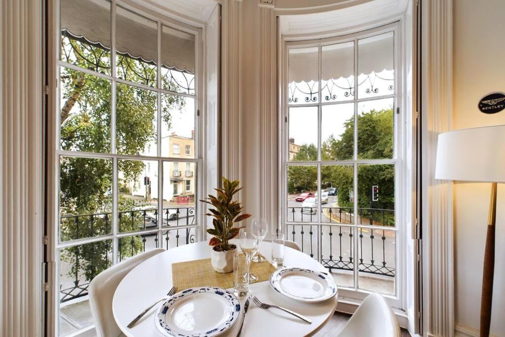 comedor con mesa, sillas y ventana en Belle Vue Regency King size w Free Parking en Cheltenham