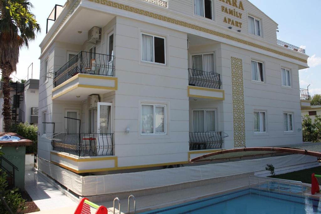 a building with a swimming pool in front of it at Kara Family Apart in Kemer