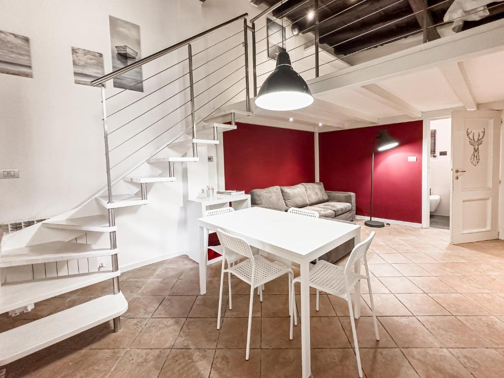 een woonkamer met een witte tafel en een trap bij Realkasa Bolognetti Apartment in Bologna