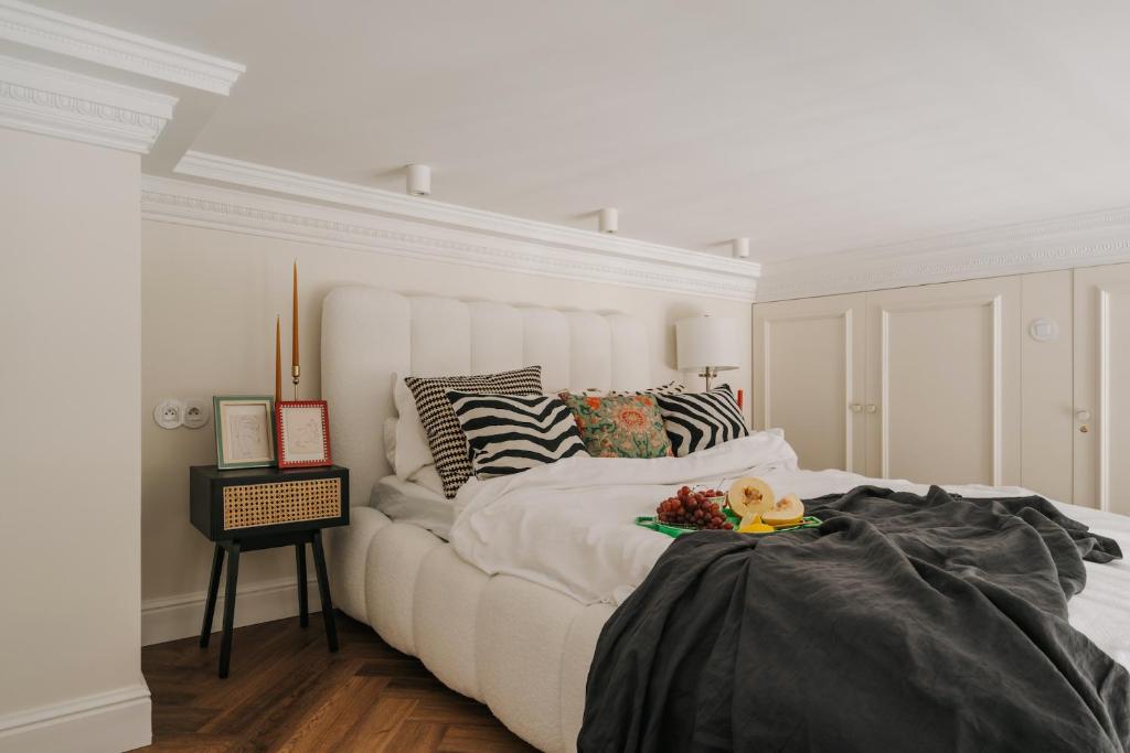 een witte slaapkamer met een groot wit bed en een tafel bij Przy Przystani Apartament Paryski in Wrocław