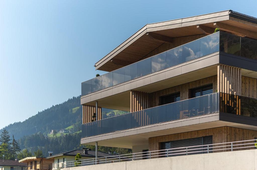 un edificio con balcón con montañas en el fondo en Fankhauser Apartments, en Ried im Zillertal