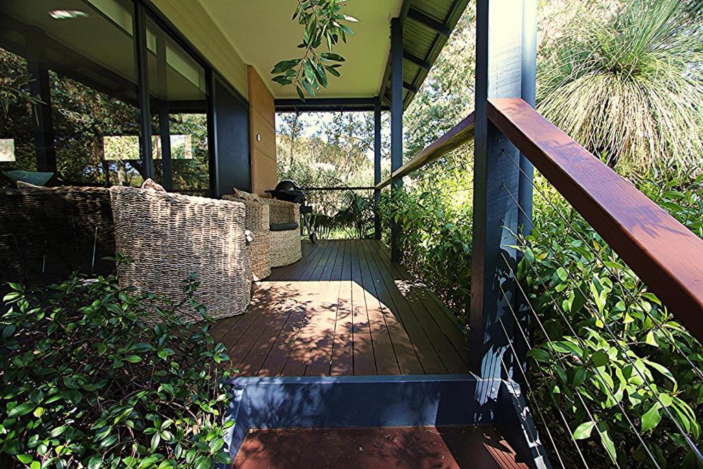 een veranda met een houten terras met stoelen erop bij Aroha in Margaret River Town