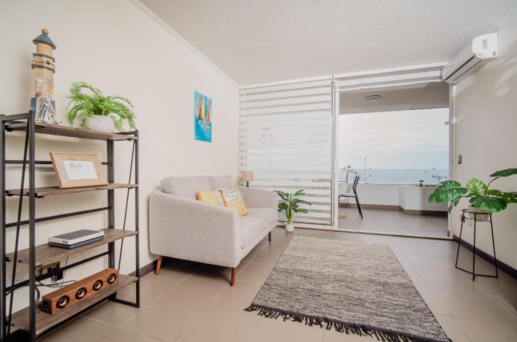 sala de estar con sofá y vistas al océano en Acogedor y hermoso departamento en primera línea de Playa Brava, en Iquique