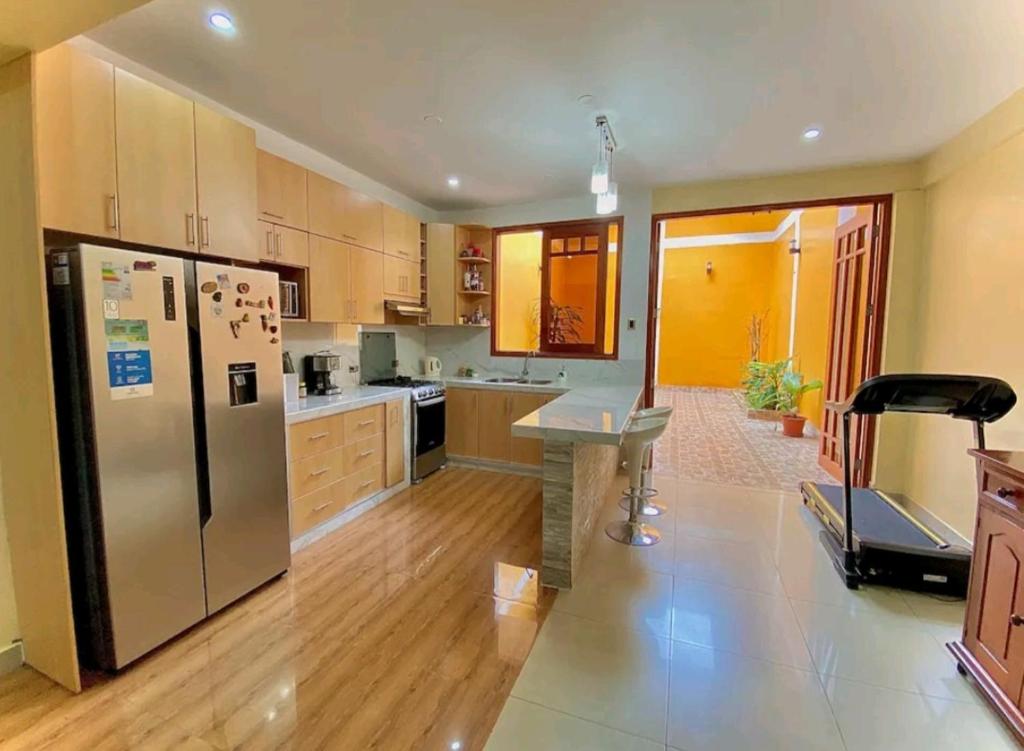 a kitchen with a stainless steel refrigerator and a treadmill at Martina House in Iquitos