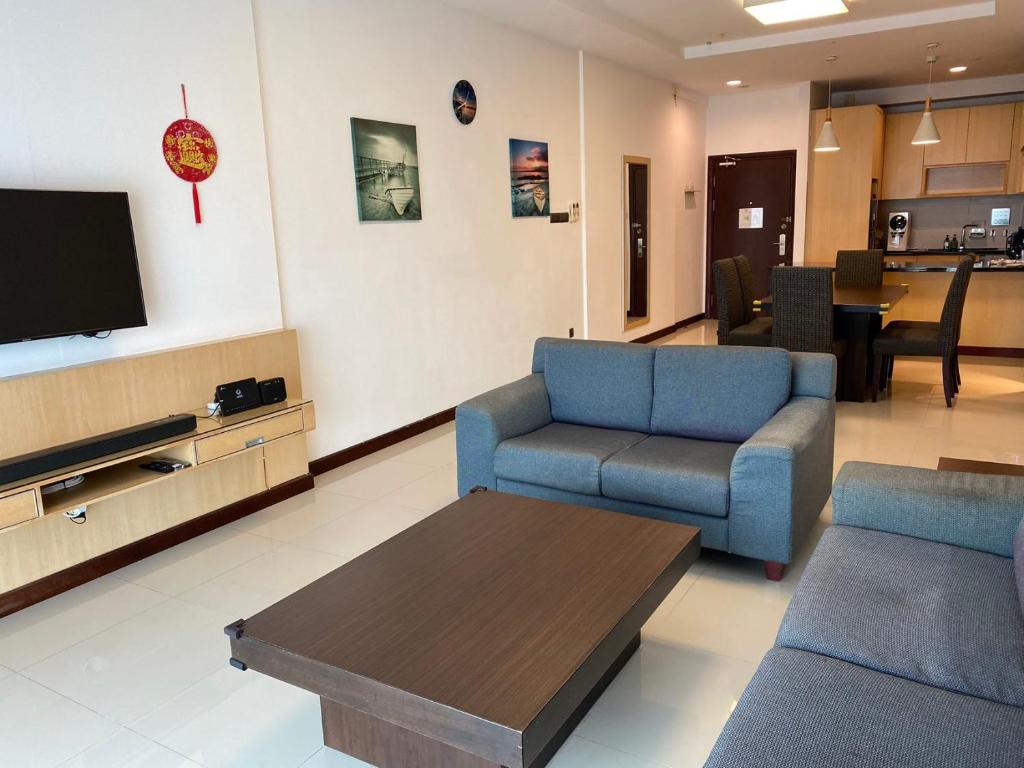 クチンにあるThe Floorspace Imperial Suites Apartmentのリビングルーム(青い椅子2脚、テレビ付)