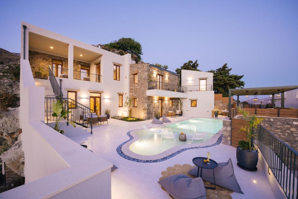 a villa with a swimming pool at night at Mirthea Suites in Myrthios