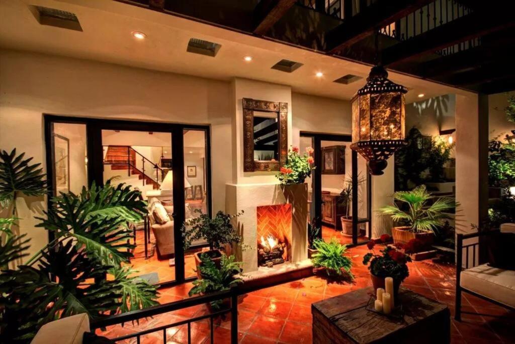 een woonkamer met een open haard en veel planten bij Santuario De La Paz - Beautiful & Comfortable Home in San Miguel de Allende