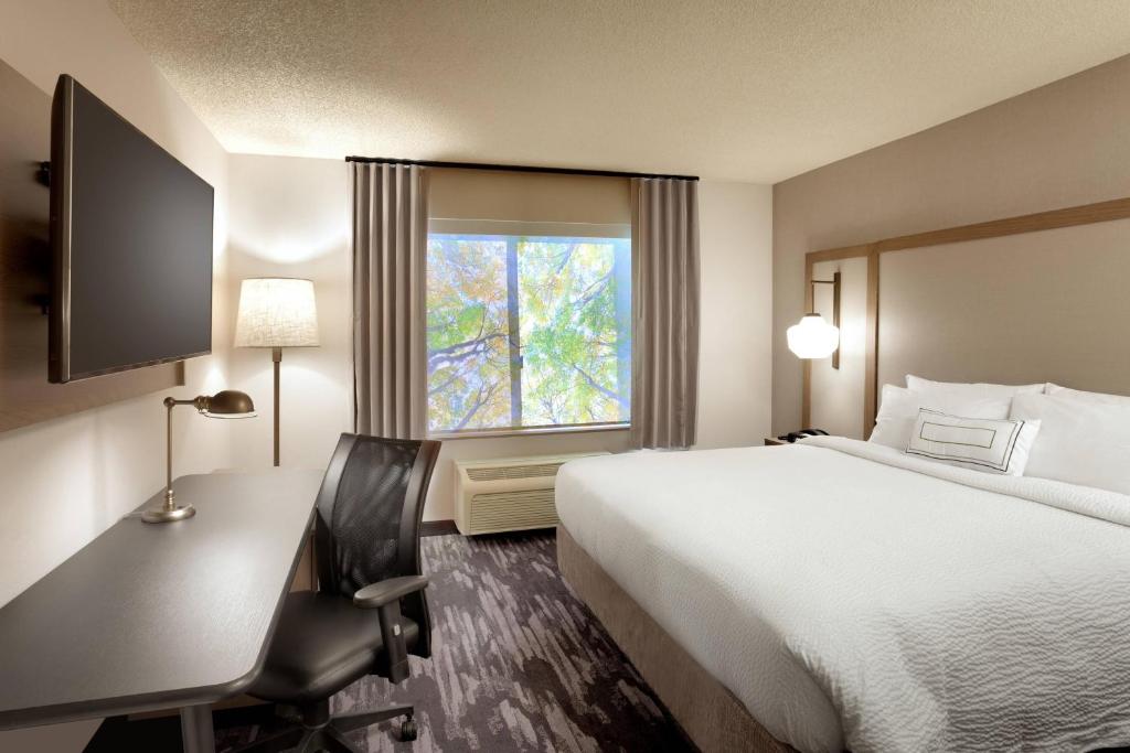 a hotel room with a bed and a desk and a window at Fairfield Inn & Suites Roswell in Roswell