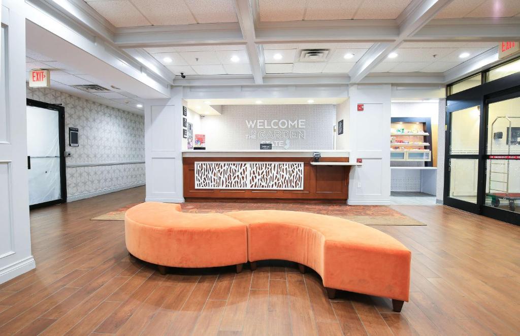 an orange bench in the middle of a store lobby at Hampton Inn Bordentown in Bordentown