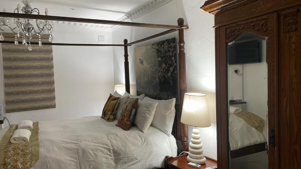 1 dormitorio con cama con dosel y espejo en Casa 57, en Pietermaritzburg