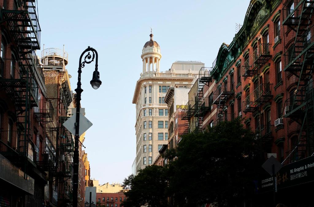 una calle de la ciudad con edificios altos y luz de la calle en Nine Orchard en Nueva York