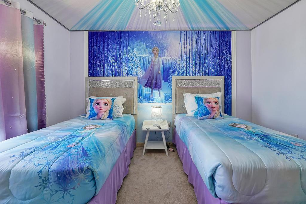 two beds in a room with a painting on the wall at Happy Planet II in Davenport