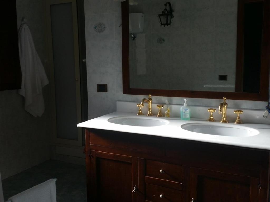 łazienka z dwiema umywalkami i dużym lustrem w obiekcie B&B del Castagneto w mieście San Marco Argentano