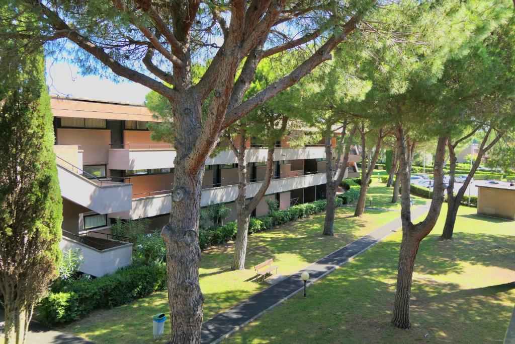 an apartment building with trees in front of it at Apartment 3 beds in Residence with swimming-pool bed and bath linen included in Marina di Bibbona