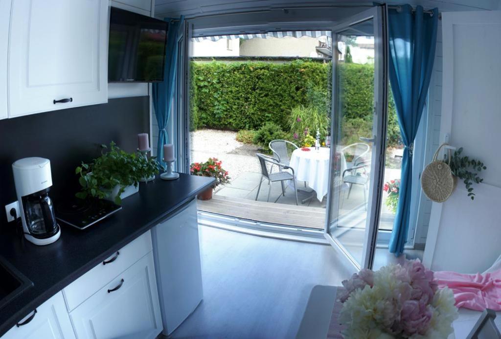 a kitchen with a view of a patio with a table at Happyfugu Domki Letniskowe in Międzyzdroje