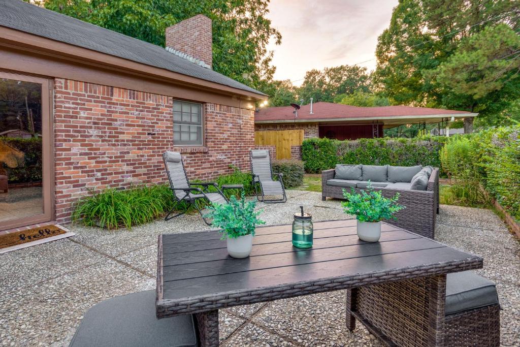 a wooden table with two potted plants on a patio at Spacious Little Rock Home with Patio - 9 Mi to Dtwn! in Little Rock
