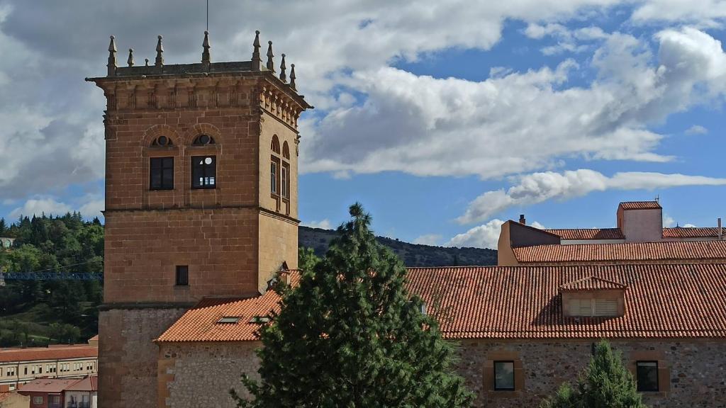 ein Gebäude mit einem Turm mit einem Baum davor in der Unterkunft El Torreón in Soria