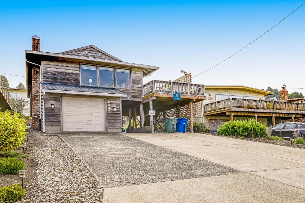 a house with a garage and a balcony at The Lucky Starfish in Lincoln City