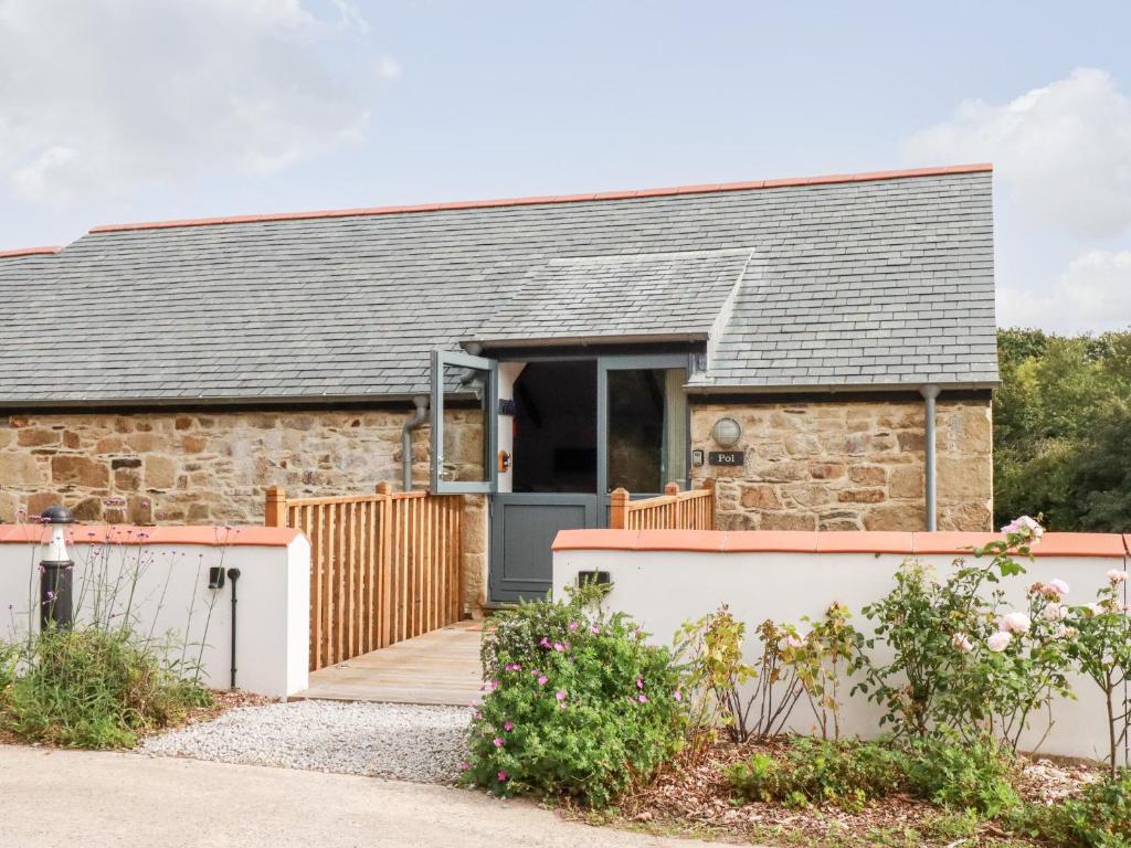 a stone cottage with a grey roof at Carines Barns - Pol in Newquay